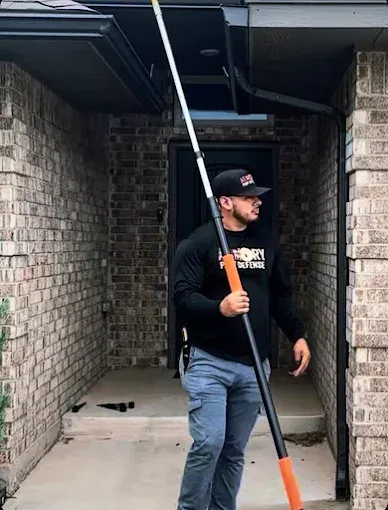 Armory Pest Defense technician carrying an extension pole for eave and soffit treatment